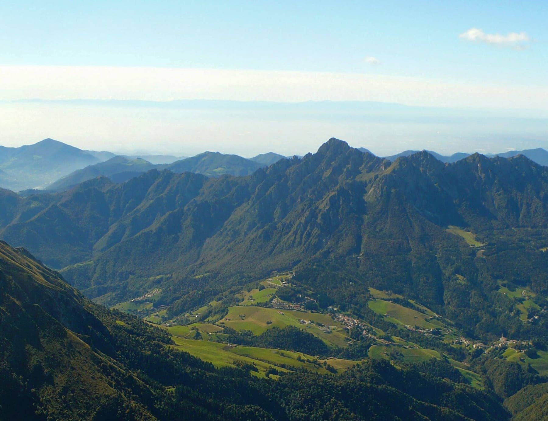 Il monte Alben e il valico di Zambla visti dal Pizzo Arera, con i paesi della conca tra i prati