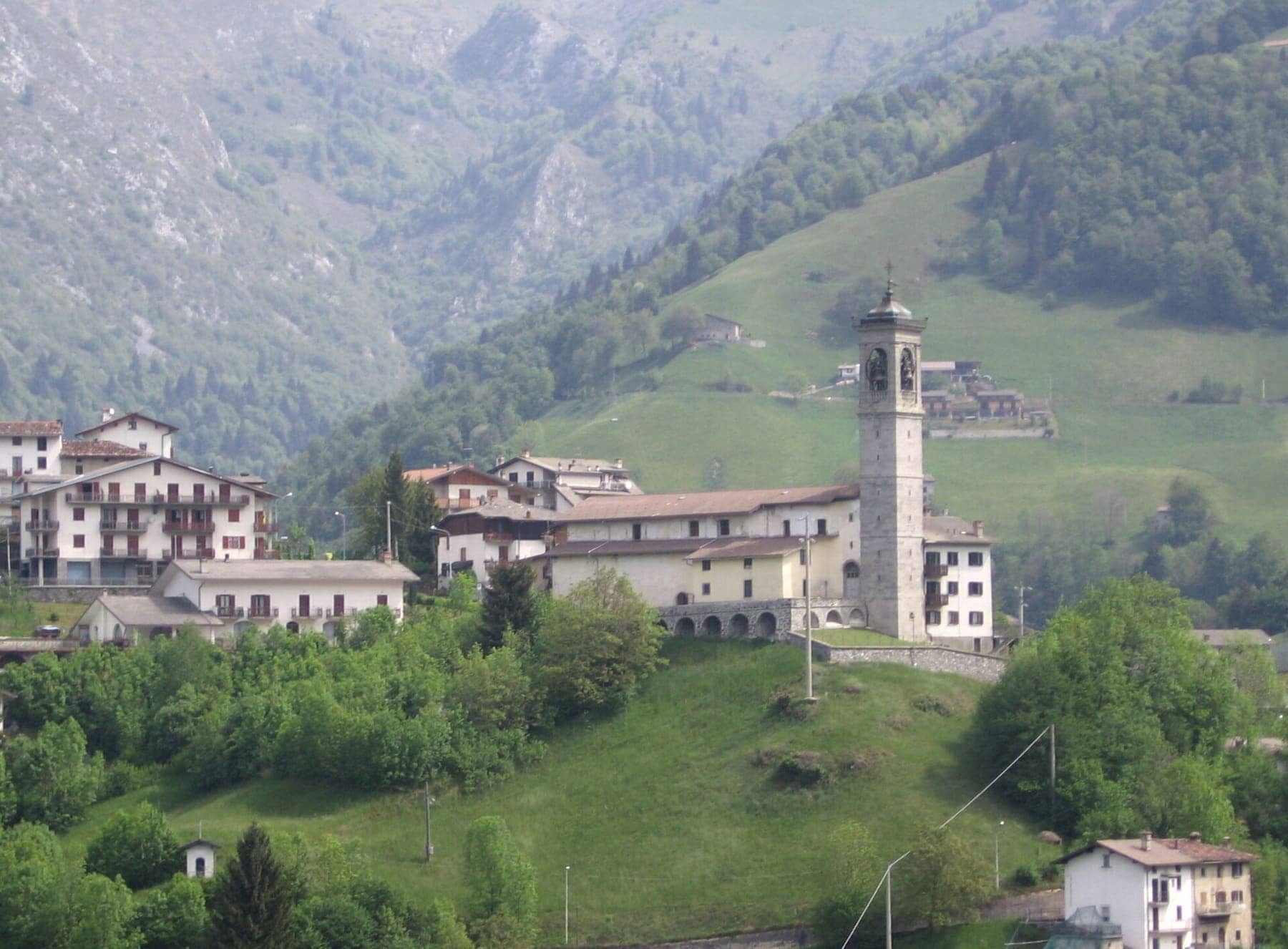 La chiesa di Santa Maria Maddalena con il campanile e le case di Zambla Bassa, frazione di Oltre il Colle