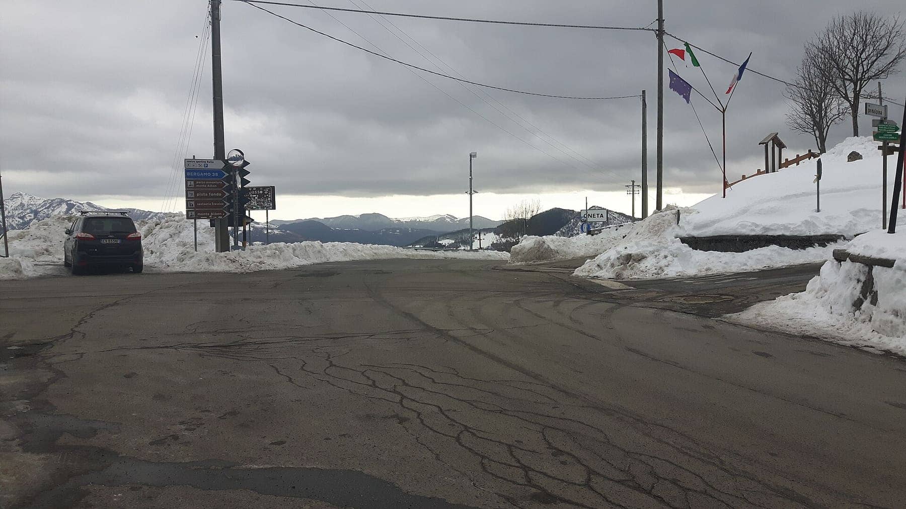 La strada al Colle di Zambla d'inverno, con i cumuli di neve spalata e i cartelli stradali del valico
