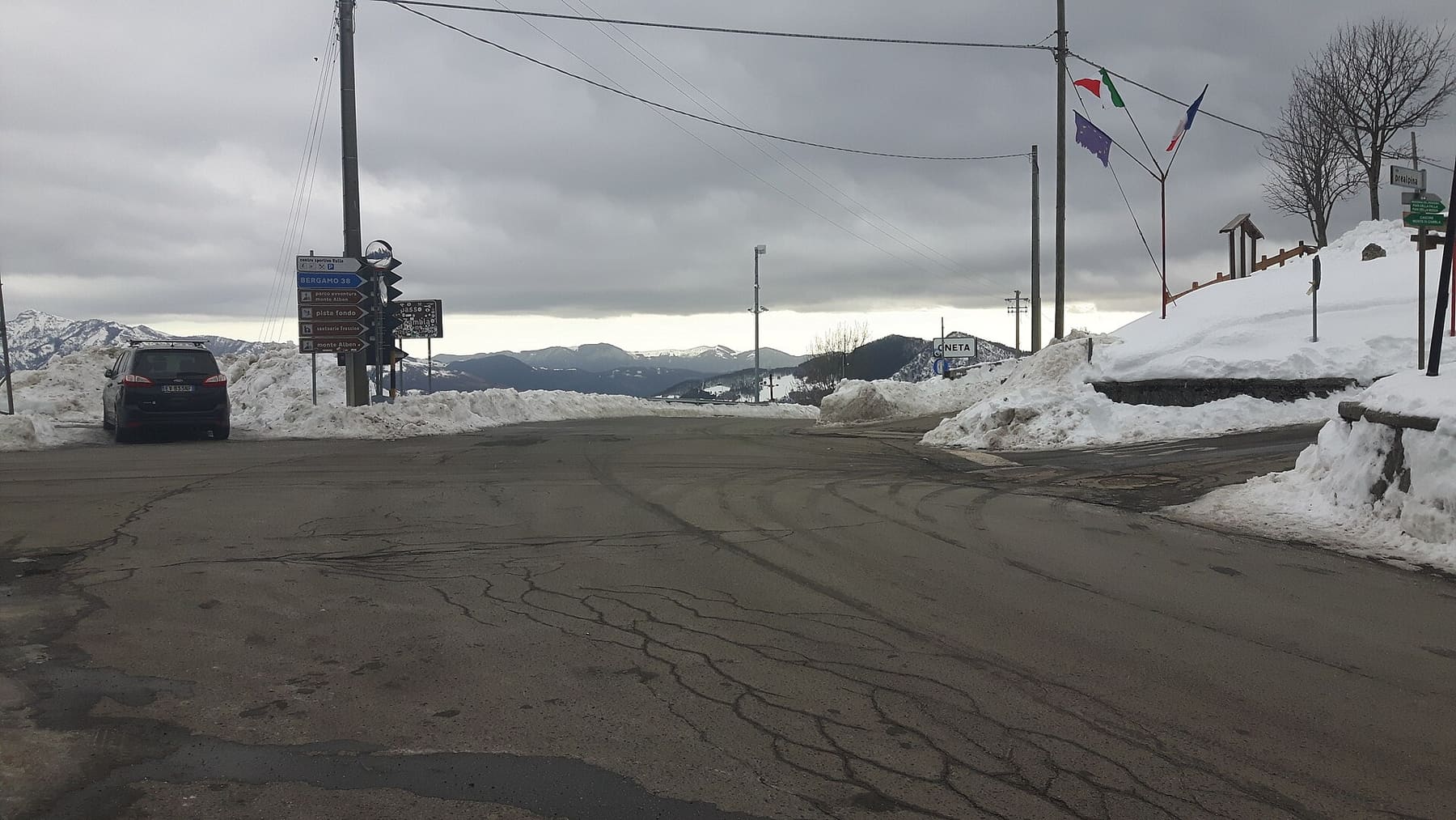 La strada al Colle di Zambla d'inverno, con i cumuli di neve spalata e i cartelli stradali del valico