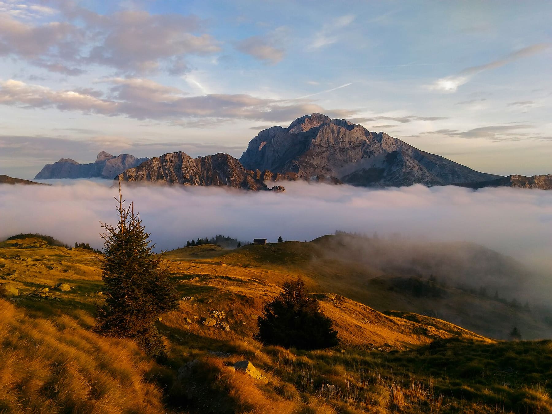Il pizzo Arera emerge da un mare di nuvole al tramonto, visto dai pressi dei Tre Pizzi in Val Brembana