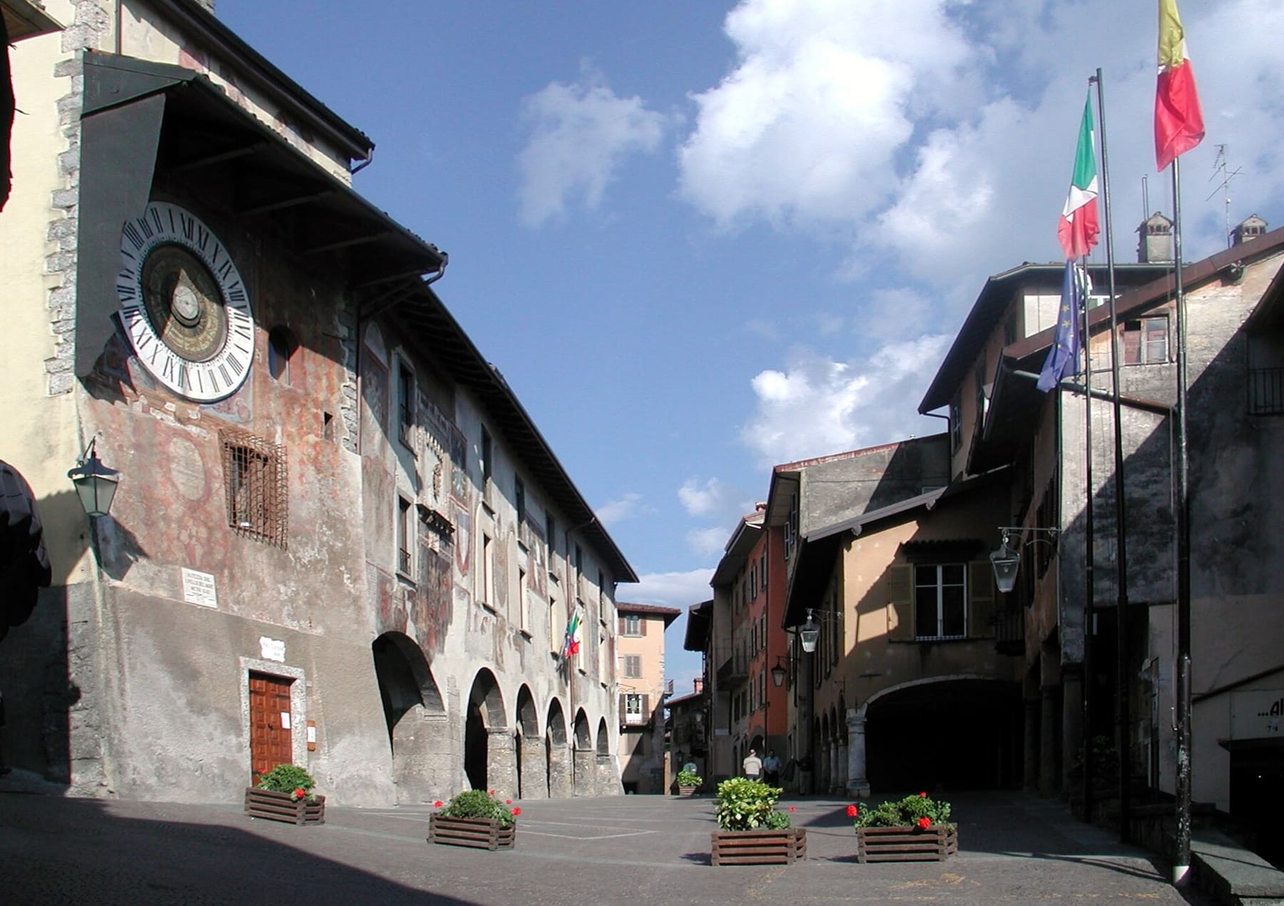 Piazza dell'Orologio a Clusone con l'orologio planetario Fanzago sul palazzo comunale affrescato e le bandiere