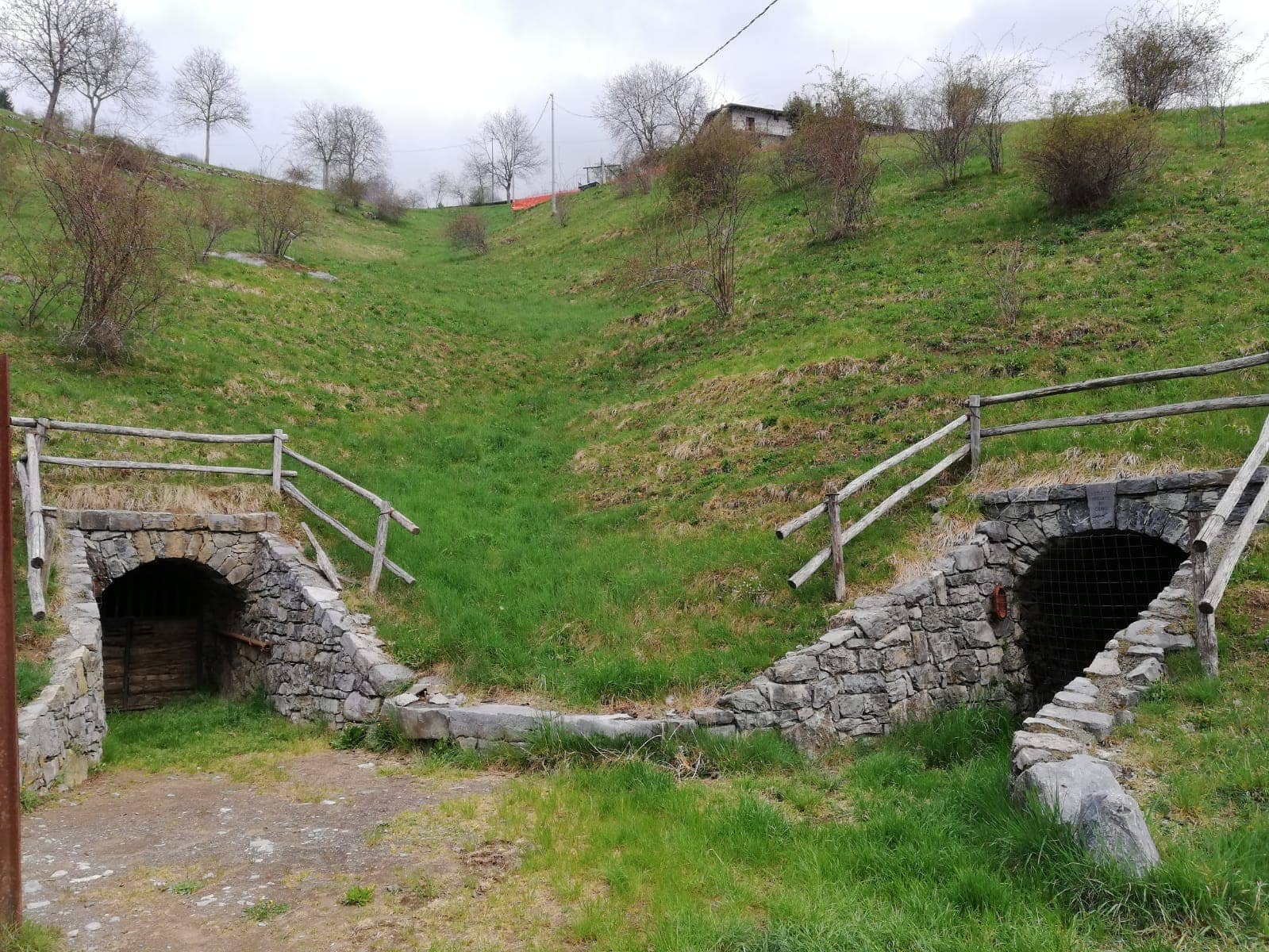 Due imbocchi di galleria mineraria restaurati sui prati dell'Ecomuseo delle miniere di Gorno, nel bacino dello zinco